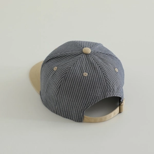 Detail view of adjustable metal buckle and blue-white striped fabric on kids baseball cap