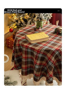 Close-up of retro red plaid round tablecloth with beige fringe detail and Christmas decor