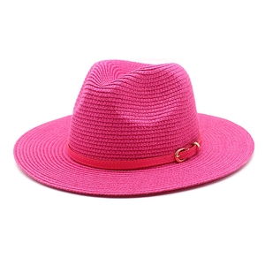 Macro detail of the woven texture and fuchsia leather belt buckle on this summer sun hat
