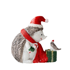 Miniature Christmas resin figurine featuring a hedgehog with hat and bird on a gift box