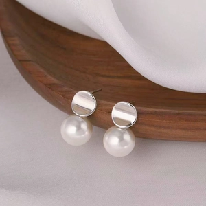French style S925 sterling silver pearl stud earrings displayed on white silk and wood