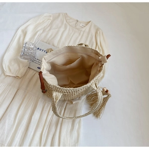 Detail view of woven straw tote bag interior with zipper pocket and fabric lining