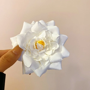 Detailed view of handcrafted white fabric gardenia hair clip with soft petals