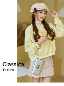Silver long wallet with butterfly ornament and wristlet strap shown in lifestyle shot