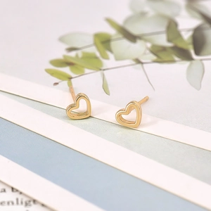 Detailed macro view of S925 sterling silver stamp on gold plated hollow heart earrings