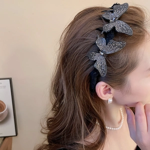 Detail of elegant black butterfly hair claw with shimmering dark grey rhinestones on a model