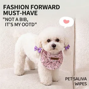 Bavaglino rosa per animali con motivi floreali e volant su un cane Bichon bianco