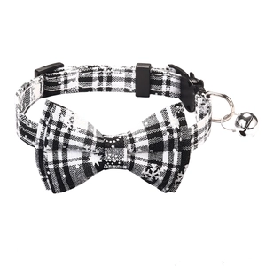 Detail of Christmas pet collar with black and white plaid bow and festive snowflake print