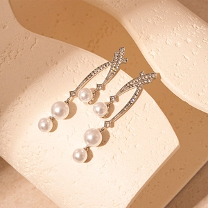 Elegant silver tassel earrings with sparkling crystals and white pearls on stone base