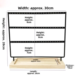 Macro view of 3-tier black metal earring organizer with 144 holes and wooden base