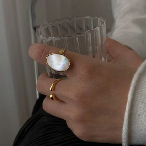 Golden open ring with oval white mother of pearl and a minimalist thin stacking band
