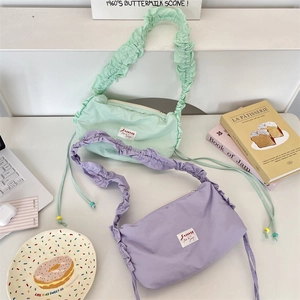 Detail of ruffled shoulder straps and beaded drawstring on pastel nylon canvas bags