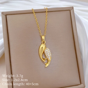 Détail du collier pendentif poisson doré avec micro-cristaux sur fond en soie de luxe