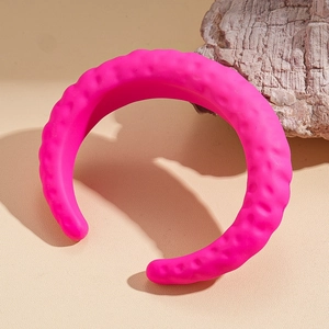 Detailansicht der Wellenstruktur auf pinkfarbenem Acryl-Armreif mit mattem Finish