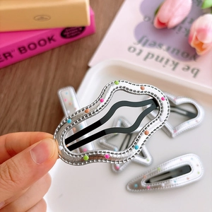 Silver leather-textured snap hair clips with colorful dots for girls in lifestyle setting