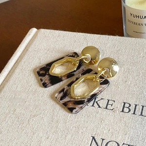 Detail of vintage leopard print resin earrings with geometric gold metal rings