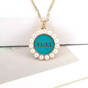 Detailed close-up of 11:11 lucky pendant with teal enamel and white faux pearls
