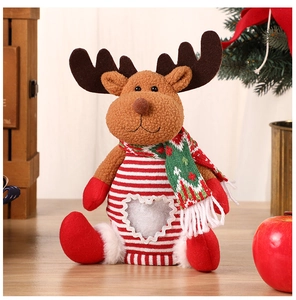 Close-up of reindeer plush toy with striped sweater and heart detail on wooden table