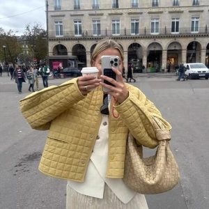 Fashionable yellow quilted plaid jacket paired with a beige woven leather handbag