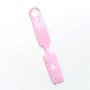 Detail of pink faux leather luggage tag showing Happy Flight text and aircraft icon