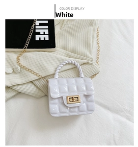 Close-up of white quilted jelly bag with gold chain strap and square twist lock