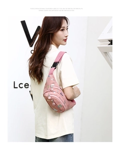 Vue latérale du sac banane en nylon rose à motifs porté par un mannequin sur fond de mur blanc