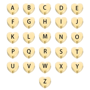 Macro view of gold heart charms with A-Z laser engraved letters for DIY jewelry making