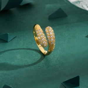 Elegant gold snake-shaped open ring with sparkling diamonds on a textured background
