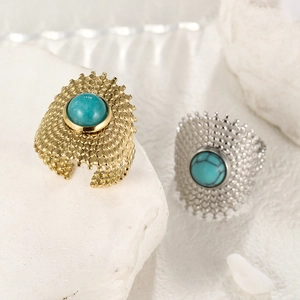 Detailed close-up of gold and silver turquoise rings on natural textured stones