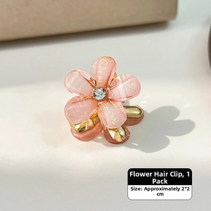 Close-up of a 2x2cm mini pink flower hair claw clip with glitter petals and center crystal