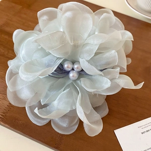 Detail shot of multi-layered white silk flower hair claw with elegant center pearls