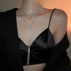 Close-up of layered silver rhinestone fringe necklace worn by model on black velvet outfit