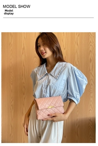 Detailed view of pink quilted crossbody bag with gold chain strap on a model