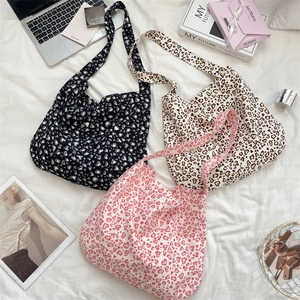 Detailed overhead view of leopard print canvas tote bags in black beige and pink styles