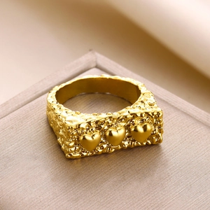 Detail of gold lava texture ring featuring three 3D hearts on a jewelry display box