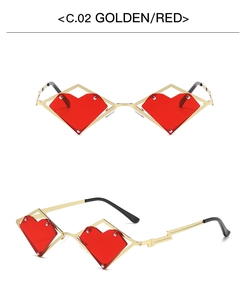 Detail view of heart-shaped sunglasses with golden metal frame and red lenses