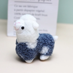 Detail of cute blue and white alpaca plush keychain with soft boucle fleece texture