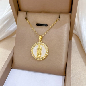 Macro detail of gold Virgin Mary pendant with pearls and zircons in a brown jewelry box