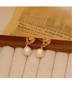 Detail showing vintage gold hollow heart earrings with elegant round white pearls