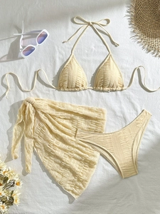 Three-piece solid cream textured bikini set with matching mesh sarong and halter top