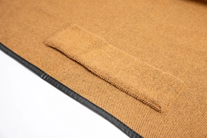 Detail of brown twill wool fabric with black leather trim and rectangular pocket