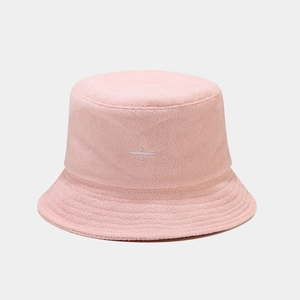 Close-up of pink terry cloth bucket hat with minimalist white embroidery detail