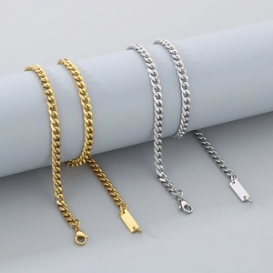 Mens silver and gold cuban link chains with rectangular square pendants on grey display