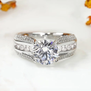 Luxurious four-prong round cut solitaire ring with pavé diamond band on marble background