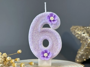 Detailed view of lavender number 6 birthday candle with glitter and floral accents