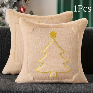 Detail of beige plush pillowcase featuring yellow embroidered Christmas tree on a sofa