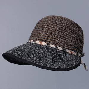 Detail of woven straw texture and plaid ribbon bow on elegant summer sun hat