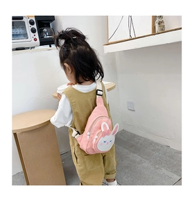 Rear view of a child wearing a cute pink cartoon bunny canvas crossbody chest bag