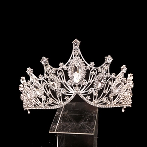 Detailed close-up of a silver bridal crown with rhinestones and oval center stone