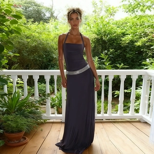 Elegant deep purple halter maxi dress with silver sequin waist detail on an outdoor patio